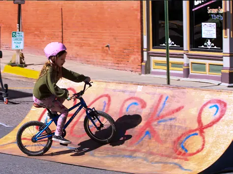 girl riding a bicycle on a skate ramp