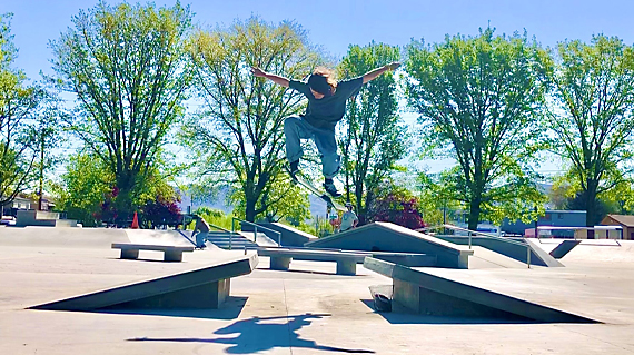 boy doing skateboaard trick over two ramps